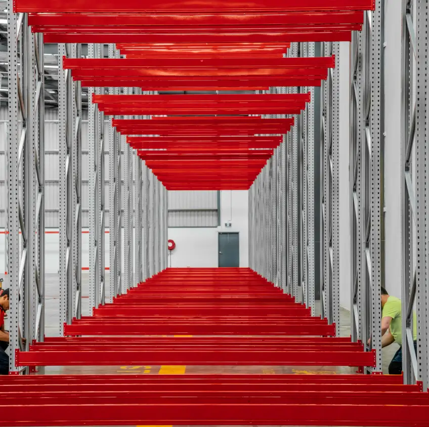 Pallet racking structure with red beams forming high density storage lanes