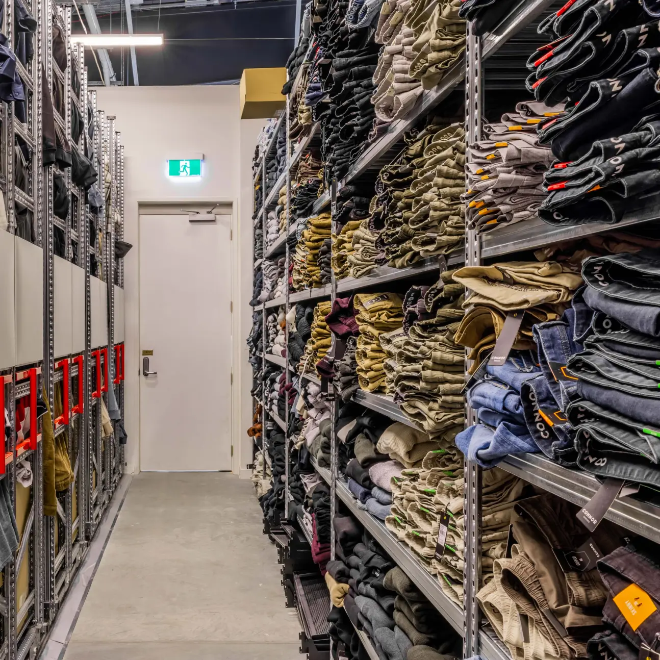 Retail stockroom shelving with mixed apparel and storage organization