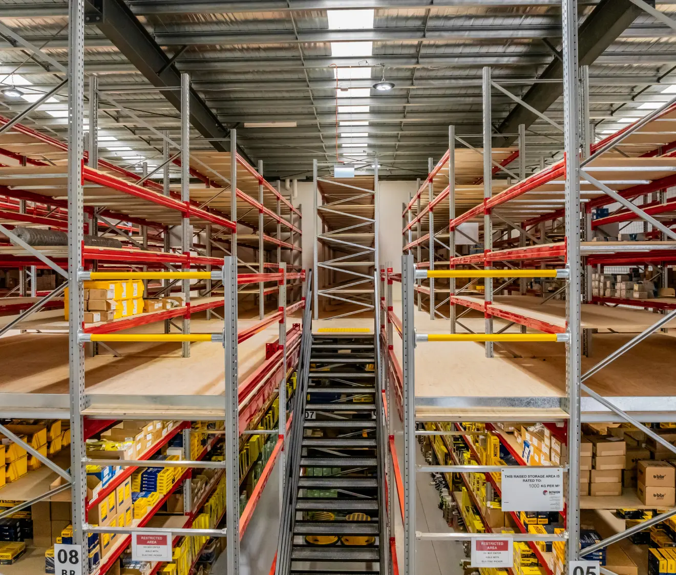 Warehouse mezzanine floor system with stairs and multi-level storage shelving