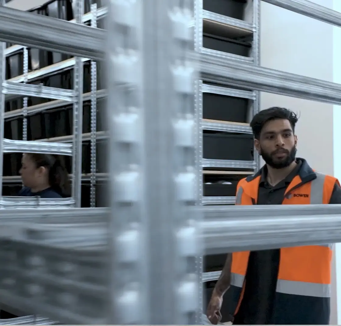 Warehouse worker inspecting metal shelving system installation in storage facility
