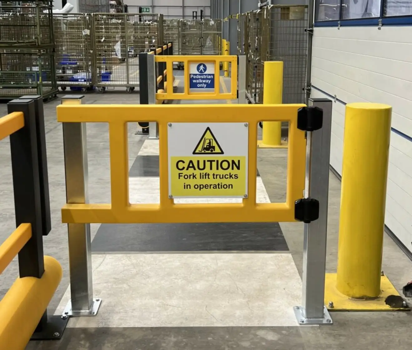 Warehouse safety gate with caution sign and pedestrian walkway barrier for forklift traffic control