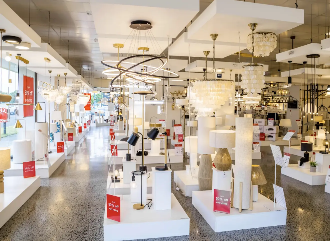 Modern retail lighting store with pendant lights, lamps, and product display shelving systems
