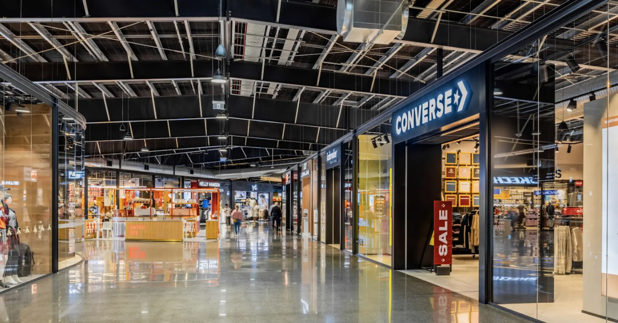 Retail shopping centre interior with storefronts, polished flooring, and open mall walkway layout