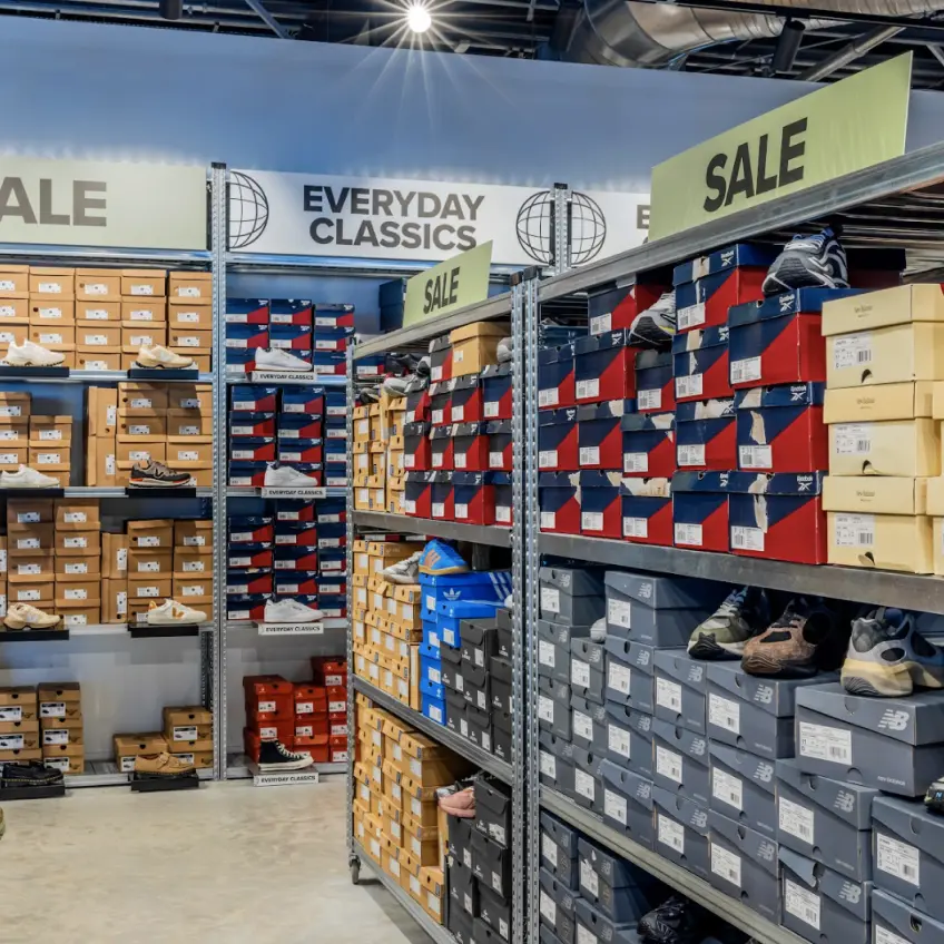 Retail shoe storage shelving with stacked boxes and sale displays for efficient product organisation