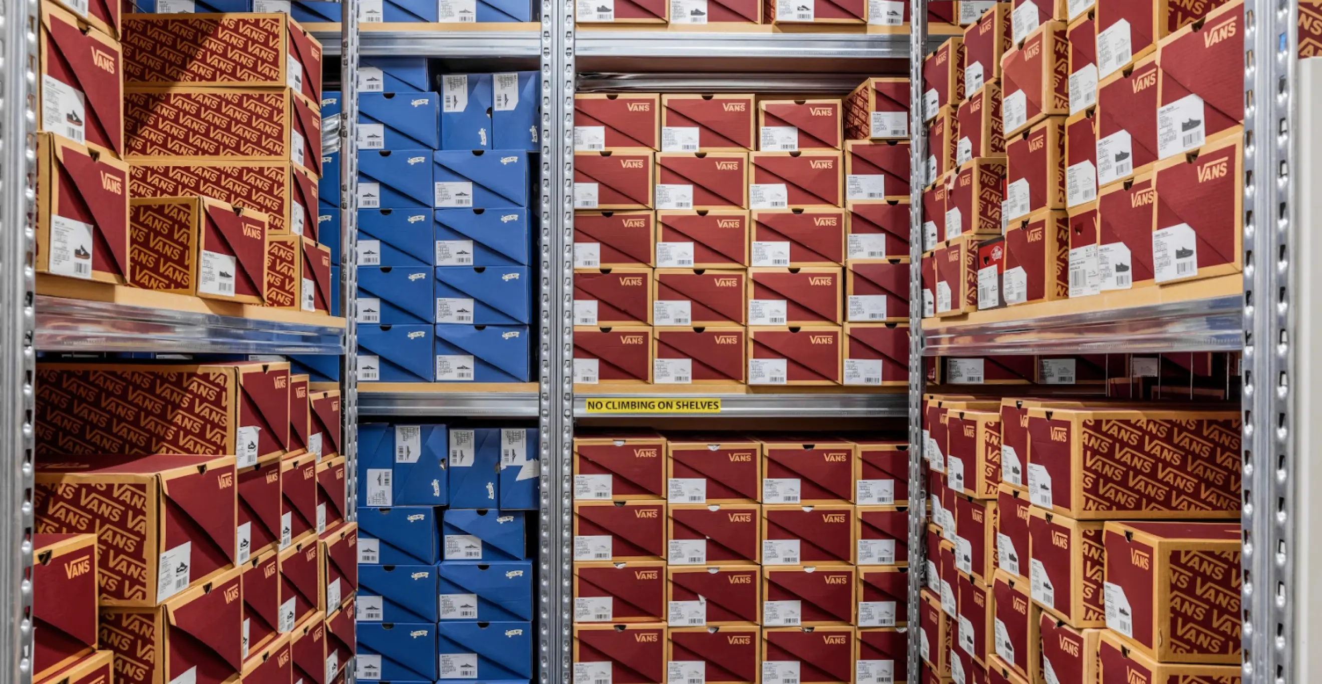Industrial shelving system storing boxed footwear with organised aisle layout for stock management