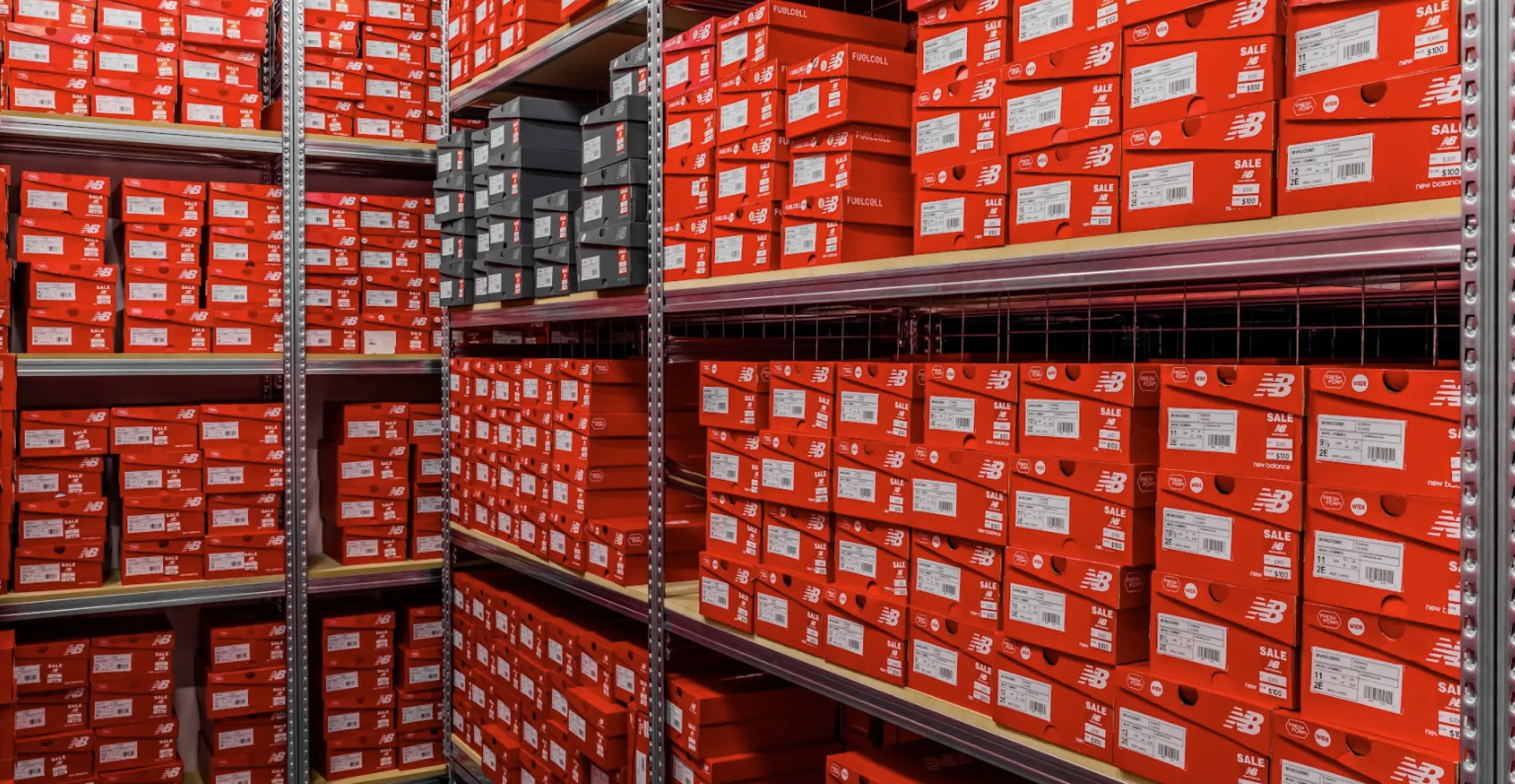 High-density long span shelving system with stacked footwear boxes in organised retail stockroom