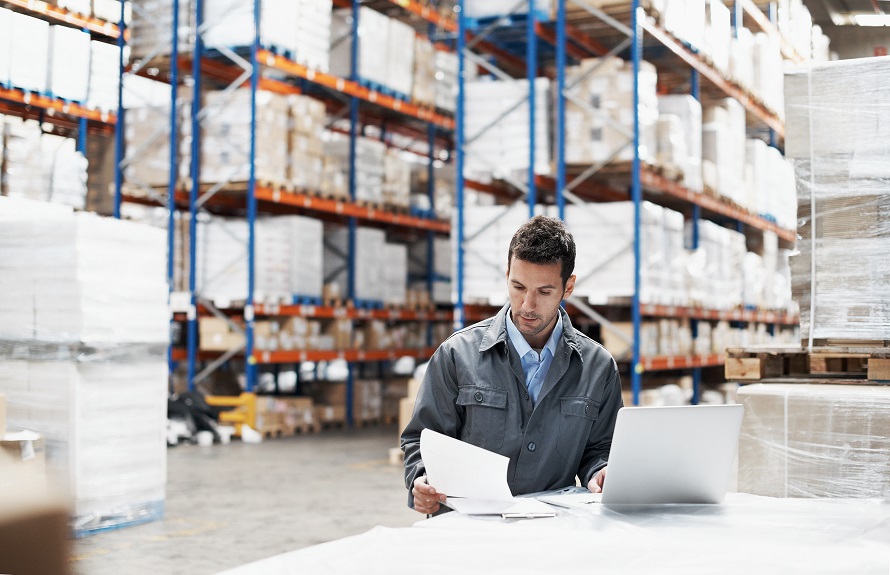 man reviewing logistics report in warehouse